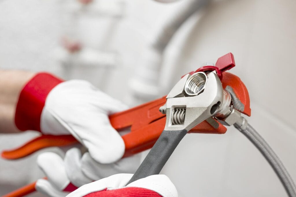 Plumber holding pipe wrenches for an emergency repair in Winter Park